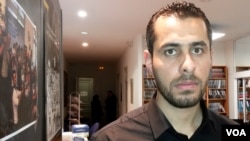 FILE - Abdulrahman Almawwas, co-founder of the Syrian White Helmets voluntary rescue force, is pictured in Paris, Feb. 13, 2018. He said it's hoped that the transitional government "will lead us to a new Syria that all Syrians dream of." 