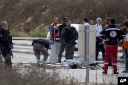 An Israeli forensic officer inspects the body of a Palestinian man at a checkpoint near the West Bank town of Nablus, Oct. 30, 2015.