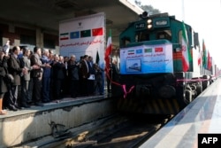 FILE - Iranian officials applaud on the platform as the first train connecting China and Iran arrives at Tehran Railway Station, Feb. 15, 2016.