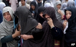 FILE - Afghan women mourn during the funeral of victims who died from a suicide attack, in Kabul, Afghanistan, July 24, 2016.