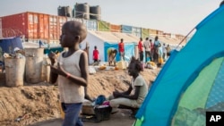 FILE - A young displaced girl washes clothes alongside a row of tents in the United Nations camp in Juba, South Sudan, Feb. 12, 2014.