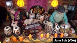 FILE - Abigail Adams Greenway and her teacher and musical partner, Masood Omari, play tabla in Greenway's basement outside Washington.