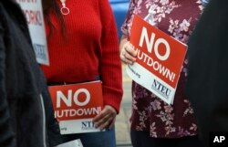 FILE - People protest the partial government shutdown in downtown Denver, Colorado, Jan. 10, 2019. Some federal workers are taking second jobs to stay afloat.