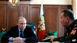 FILE - Russian President Vladimir Putin, left, and Commander-in-Chief of the Interior Ministry troops Viktor Zolotov attend a meeting in the Kremlin in Moscow, Russia, April 5, 2016.