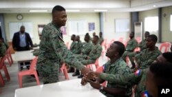 A member of Haiti's new national military force greets a fellow soldier in a meeting room at a former U.N. base in Gressier, Haiti, April 11, 2017.