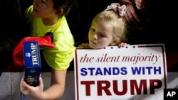 A young girl stands at the rope line at a rally in support of Republican presidential candidate Donald Trump at Muscatine High School in Muscatine, Iowa, Jan. 24, 2016.