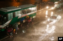 Commuters brave the rain and strong winds brought about by Typhoon Mangkhut, which barreled into northeastern Philippines before dawn, Sept. 15, 2018, in Manila, Philippines.
