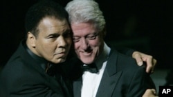 FILE - Former boxer Muhammad Ali, left, hugs former U.S. President Bill Clinton as he walks onstage at the grand opening gala celebration for the Muhammad Ali Center in Louisville, Kentucky, Nov. 19, 2005.