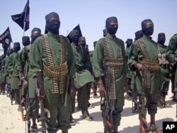 FILE - A February 2011 photo shows al-Shabab fighters on parade with their guns during military exercises on the outskirts of Mogadishu,Somalia.