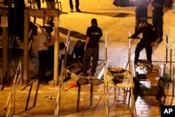 Israeli police officers dismantle metal detectors outside the al-Aqsa Mosque compound in Jerusalem's Old City, July 25, 2017.