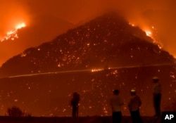 Firefighters monitor the Thomas fire as it burns through Los Padres National Forest near Ojai, California, Dec. 8, 2017.