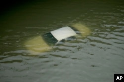 A car is submerged on a freeway flooded by Tropical Storm Harvey, Aug. 27, 2017, near downtown Houston, Texas.
