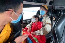 People wear masks on a bus in Quang Ninh province, Vietnam, Jan. 28, 2018. A tourism company director in Vietnam says the coronavirus outbreak that began in China has hit his industry “very hard, like a giant bomb."