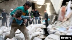 A man carries an injured child who was taken out from under debris at a site after what activists said was shelling by forces loyal to Syria's President Bashar al-Assad in Al-Sukkari neighbourhood in Aleppo, Feb. 2, 2014.
