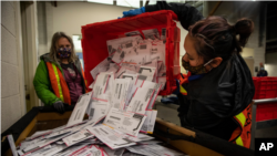 Nhân viên bầu cử đang đổ thùng phiếu ra để đếm trong cuộc bầu cử năm 2020 ở hạt Multnomah, bang Oregon