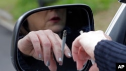 A woman smokes a cigarette while sitting in her truck in Hayneville, Alabama. March 2, 2013. (AP Photo/Dave Martin)