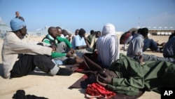 FILE - African migrants rest after their rescue by the Libyan Coast Guard west of Tripoli, Dec. 21, 2015. The International Organization for Migration says it is scaling up the repatriation of African migrants suffering abuse and exploitation in Libya, mainly at the hands of the police and the militias.