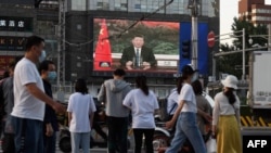 Građani Pekinga na video bimu gledaju obraćanje predsednika Kine Ši Đinpinga Svetskoj zdravstvenoj skupštini 18. maja 2020. (Foto: AFP)