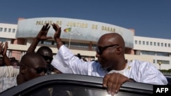 Le député socialiste sénégalais et membre de la coalition au pouvoir, Barthélemy Dias, salue les sympathisants alors qu'il quitte le palais de justice de Dakar le 1er décembre 2016.