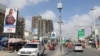 Motorists drive past the campaign billboard of Somalia's opposition presidential candidate Abdirahman Abdishakur Warsameh along the main streets of Mogadishu, Somalia, Feb. 8, 2021.