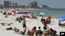 Para pengunjung mendatangi pantai sambil mempraktikan menjaga jarak aman untuk mencegah penularan virus coroa di Pantai Clearwater, Blorida, 4 Mei 2020. (Foto: AP)