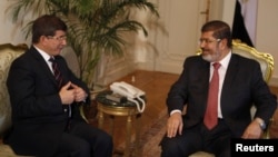 FILE - Former Egyptian President Mohamed Morsi (R) meets with Turkey's Foreign Minister Ahmet Davutoglu at the presidential palace in Cairo, Sept. 17, 2012. 