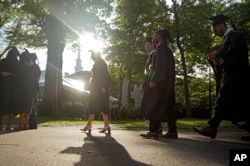 FILE - Graduates walk at a Harvard Commencement ceremony held for the classes of 2020 and 2021, May 29, 2022, in Cambridge, Mass. (AP Photo/Mary Schwalm, File)