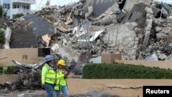 Rescatistas caminan entre los escombros después de la demolición controlada de la parte restante del complejo Champlain Towers South mientras continúan los esfuerzos de búsqueda y rescate en Surfside, Florida, el 6 de julio de 2021.