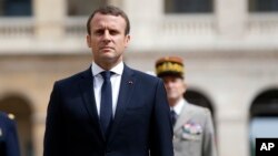 France's President Emmanuel Macron observes the French Flag, during a military ceremony, at the Hotel des Invalides, in Paris, June 30, 2017. 