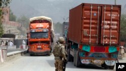 U.S. soldier watches trucks crossing Torkham gate border between Afghanistan and Pakistan in Nangarhar province, Afghanistan, July 21, 2011.