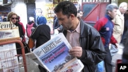 A man reads a newspaper headlining "Terrorist attack and kidnapping in In Amenas," at a news stand in Algiers, January 17, 2013. 
