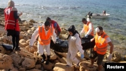 Rescue workers carry a bag containing the dead body of a migrant that washed ashore in Tripoli's Janzour city, Libya, Nov. 5, 2016. 