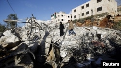 Parents of Palestinian Mohanad Al-Halabi inspect their house after it was demolished by Israeli troops in the village of Surda, near the West Bank city of Ramallah, Jan. 9, 2016. 