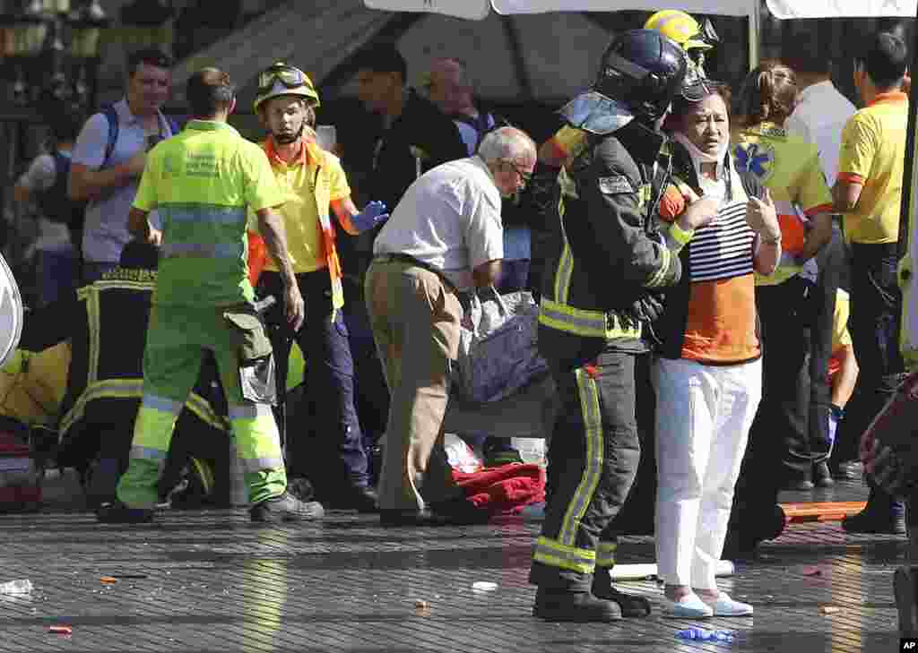 Injured people are treated in Barcelona, Spain, Aug. 17, 2017 after a van jumped the sidewalk in the historic Las Ramblas district, crashing into a summer crowd of residents and tourists.