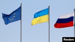 Flags of the European Union (L-R), Ukraine and Russia fly during the arrivals of leaders and delegations at an airport outside Minsk August 26, 2014. (Vasily Fedosenko/Reuters)