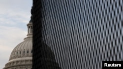 The U.S. Capitol dome is seen behind a security fence in Washington, Jan. 11, 2021. 