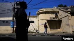 Anti-terror policemen stand guard following a bomb blast at a police office in Surabaya, Indonesia, May 14, 2018. 