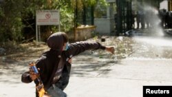 Seorang demonstran melemparkan bom molotov ke arah barisan anggota Garda Nasional Meksiko dalam aksi protes terhadap keputusan pemerintah Meksiko untuk mengalihkan air dari bendungan La Boquilla ke AS, di Camargo, Chihuahua, Meksiko, 8 September 2020.(REUTERS/Jose Luis Gonzalez)