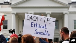 FILE - A person holds up a sign in support of the Deferred Action for Childhood Arrivals, known as DACA, and Temporary Protected Status programs during a rally in support of DACA and TPS outside of the White House, in Washington.