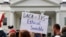 FILE - A person holds up a sign in support of the Deferred Action for Childhood Arrivals, known as DACA, and Temporary Protected Status programs during a rally in support of DACA and TPS outside of the White House, in Washington.