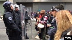 Police face off with protesters as Donald Trump is sworn-in as the 45th President of the United States in Washington, D.C., Jan, 20, 2017. (J. Swicord/VOA)