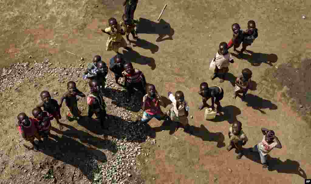 Anak-anak pengungsi Sudan Selatan memandangi sebuah truk yang memompakan air ke reservoir di menar air, di sebuah bagian di komplek perumahan yang terbuat dari dinding tanah dan tenda yang membentuk pemukiman pengungsi Bidi Bidi di bagian utara Uganda.&nbsp; Bidi Bidi saat ini adalah pemukiman pengungsi terbesar di dunia yang menamung beberapa dari pengungsi yang menghindari perang saudara di Sudan Selatan.