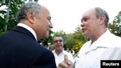 France's Foreign Minister Laurent Fabius (L) talks to Cuba's Minister of Foreign Trade and Commerce Rodrigo Malmierca Diaz (R) after a news conference in Havana, April 12, 2014.