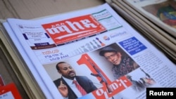 FILE - Ethiopia’s Prime Minister Abiy Ahmed and leader of the Tigray People&#39;s Liberation Front (TPLF) party Debretsion Gebremichael are pictured on the Maleda Local News papers, in Addis Ababa, Nov. 3, 2021.