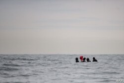 Migrantes navegan en un barco en aguas agitadas entre Sangatte y Cap Blanc-Nez, en el Canal de la Mancha frente a la costa del norte de Francia, mientras intentan cruzar las fronteras marítimas entre Francia y el Reino Unido, el 27 de agosto de 2020.