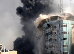 The building housing offices of The Associated Press and other media in Gaza City collapses after it was hit by an Israeli airstrike, May 15, 2021. The attack came about an hour after the Israeli military warned people to evacuate the building.