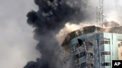 The building housing the offices of The Associated Press and other media in Gaza City collapses after it was hit by an Israeli airstrike May 15, 2021.