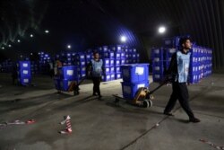 Afghan election workers transport ballot boxes for distribution ahead of presidential elections, at the Independent Election Commission compound, in Kabul, Afghanistan, Sept. 23, 2019.