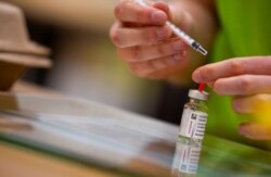 A pharmacist prepares to fill a syringe with the AstraZeneca COVID-19 vaccine at the Vaccine Village in Antwerp, Belgium, March 16, 2021.