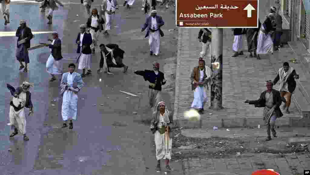 February 18, 2011: Supporters of the Yemeni government hurl stones at anti-government demonstrators, not pictured, during clashes in Sanaa on what organizers called Friday of Rage.